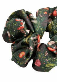 Dark green fabric scrunchie featuring a pattern of whimsical animals, mushrooms, and flowers in vibrant colors. Soft, smooth texture.