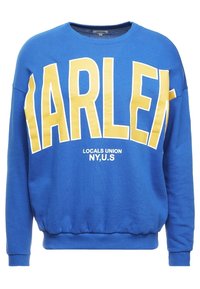 Sudadera azul con gran texto amarillo "HARLEM" y texto más pequeño blanco "LOCALS UNION NY, EE.UU." Puños y dobladillo acanalados. Textura de tela suave.