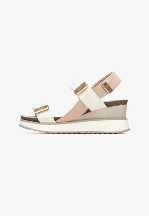 Sandalia de cuña con tiras beige y blancas, plantilla de corcho y detalles en dorado. Cuenta con una suela texturizada y diseño de tiras traseras para mayor soporte.