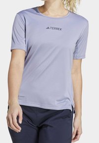 Lichtpaars sportshirt met korte mouwen en een ronde hals. Voorzien van het "TERREX" logo op de borst en "AEROREADY" branding aan de onderkant.