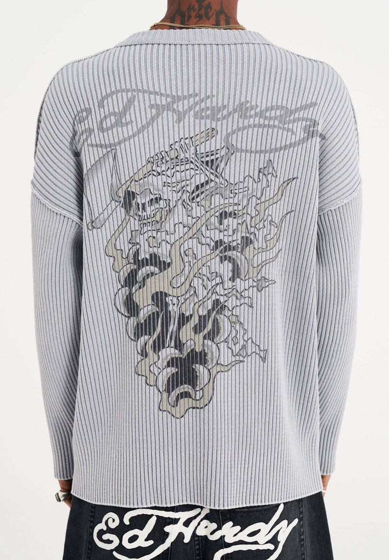 Grey ribbed sweater featuring a graphic design of skulls and smoke on the back. Long sleeves with a relaxed fit.