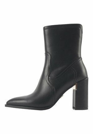 Black leather ankle boot with a pointed toe and a high square heel. Features subtle stitching and a smooth texture.