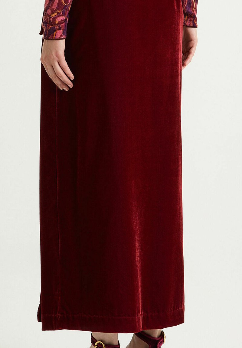 Langer, weinroter Samtrock mit glatter Textur und dezentem Glanz. Verfügt über einen geraden Schnitt und Saum mit sauberen Nahtdetails.