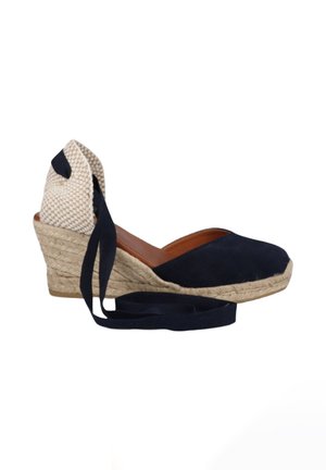 Scarpa espadrille con zeppa con tomaia in tessuto blu navy, suola intrecciata in juta, copri tallone beige a quadretti e lunghi lacci blu navy per la caviglia.