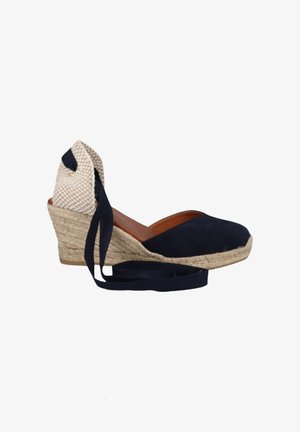 Scarpa espadrille con zeppa con tomaia in tessuto blu navy, suola intrecciata in juta, copri tallone beige a quadretti e lunghi lacci blu navy per la caviglia.