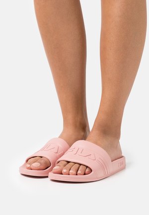 Infradito di gomma rosa con una fascia larga con logo in rilievo, design open-toe e suola piatta. La superficie è liscia e opaca.