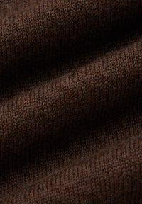 Brązowa dzianina o miękkiej fakturze, ukazująca drobne ściegi i delikatne układanie się materiału. Kolory wahają się od ciemnego do jaśniejszego brązu.