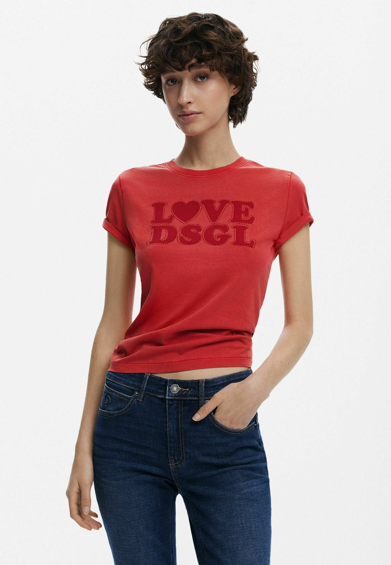 T-shirt in cotone rosso con maniche arrotolate, caratterizzata da una grande scritta "LOVE" accompagnata da un cuore e "DSGL" in un colore e una texture contrastanti, design aderente.