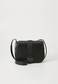 Bolso bandolera de cuero negro con forma curva, solapa frontal y placa de logo dorada. Cuenta con una correa desmontable y textura suave.