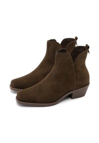 O pereche de cizme de gleznă din suede maro închis, cu tocuri joase și împăturite, vârful rotund și tab-uri de tragere la spate, pe un fundal alb.