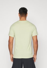 Nike Performance CREW SOLID - Spordi T-särk - olive aura