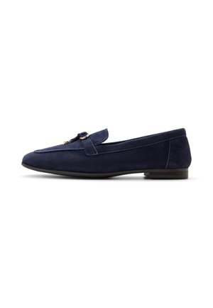 Mocasín de ante azul marino con tacón bajo y detalle metálico dorado en la parte superior, diseñado para uso casual o formal.
