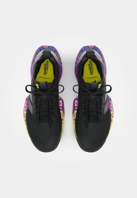 Scarpe sportive nere con una tomaia texturizzata, caratterizzate da un design grafico colorato che passa dal viola al giallo sulla suola.