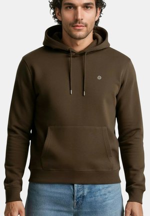 Sweat à capuche marron en tissu doux, doté d'une poche avant, de cordons de serrage et d'un petit logo sur la poitrine. Associé à un jean bleu clair.