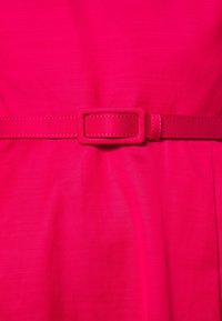 Fuchsiové šaty s širokým pasem s obdélníkovou sponou a hladkou texturou, které se vyznačují jednoduchým, strukturovaným designem.