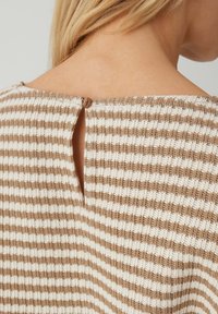 Top a righe color cuoio e bianco con chiusura a bottoni e piccolo occhiello sul retro, in tessuto lavorato a maglia strutturata.