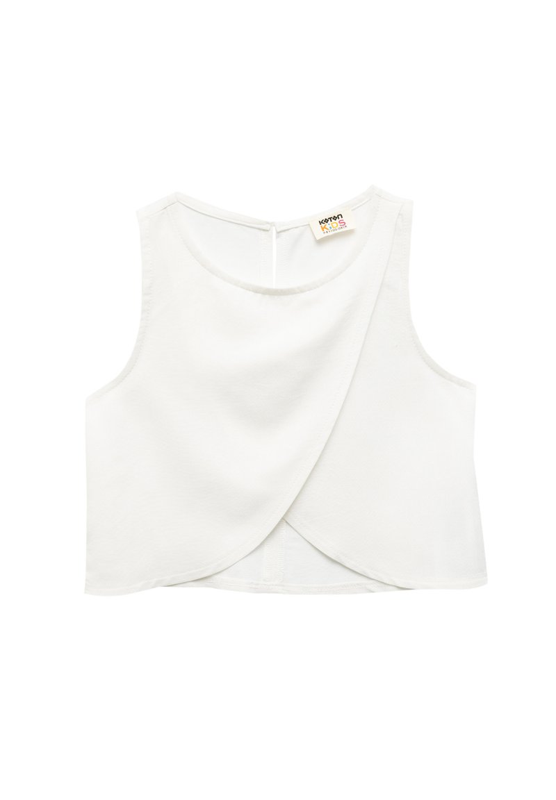 Haut sans manches blanc avec un design enveloppant, fabriqué en tissu doux. Présente un col rond et une petite ouverture à l'arrière avec un bouton.
