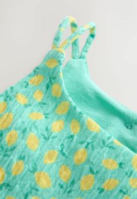 Fény teal színű ruha sárga citrommintával és zöld kiegészítőkkel, állítható pántokkal és puha, textúrált anyaggal.