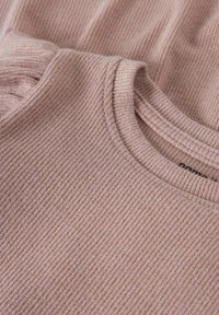 Top rosa chiaro a coste con scollatura rotonda, caratterizzato da una consistenza morbida e un leggero lucido, che mette in evidenza i dettagli delle cuciture e la struttura del tessuto.