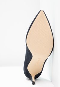 Chaussure à talon haut en daim noir avec bout pointu, semelle intérieure texturée et talon effilé. Taille 37 indiquée sous la chaussure.