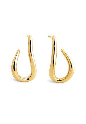 Paire de boucles d'oreilles créoles ouvertes ton or brillant avec une forme lisse, courbée et irrégulière et des fermetures à tige sur fond blanc.