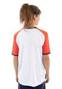 Sportshirt mit Raglanärmeln in Weiß und orangen Ärmeln, marineblauen Akzenten und atmungsaktivem Material. Die Rückansicht zeigt den lässigen Schnitt.