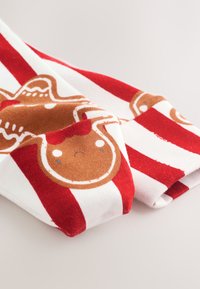 Czerwono-biały pasiasty materiał z wzorem brązowego pierniczka o smutnym wyrazie twarzy, wykonany z miękkiej bawełny.