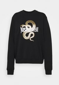 Svart sweatshirt med långa ärmar, med en guldig ormdesign och vit text "Just Cavalli" på framsidan. Slät tygkvalitet.
