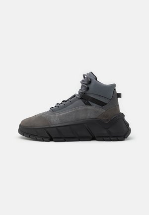 High-top dark gray and black sneaker with suede and mesh materials, thick textured sole, padded ankle collar, and lace-up closure.
