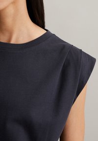 Navy blue cotton t-shirt featuring a rounded neckline and short, slightly rolled sleeves, with a smooth texture and minimal seams.