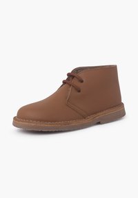 Bruine leren enkelboot met ronde neus, vetersluiting en lichtbruine zool. Heeft stiksels langs de zool en een zachte binnenvoering.