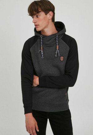 Sudadera con capucha en gris y negro con un acabado texturizado, cordones ajustables y un pequeño parche de logo en el pecho.