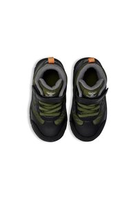 Zapatillas con cierre de velcro en negro y verde oliva con parte superior texturizada, cuello acolchado y tirador naranja en contraste. Suela de goma para mayor agarre.