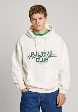 Crème hoodie met een voorprint "PJL 1973 Pepe Jeans London CLUB" in groen en marineblauw. Voorzien van een kangoeroe-zak en ribgebreide manchetten en zoom. Blauwe jeans.