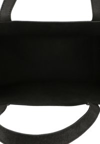 Crna torba na rame s mekanom teksturom nalik brušenoj koži. Unutrašnjost otvorena, bez dodatnih odjeljaka. Zaobljene ručke s obje strane.
