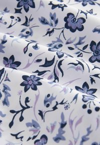 Material alb cu un model floral în nuanțe de albastru și mov, având flori stilizate, frunze și tulpini curbe.