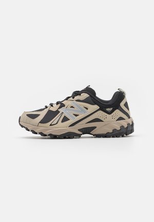 Beige og sort New Balance sportssko med chunky sål, mesh og læderoverdel samt reflekterende sølv "N" logo på siden.