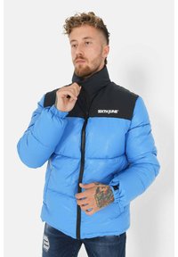 Blauwe en zwarte donsjack met een hoge kraag, voorrits, elastische manchetten en het logo "SIXTH JUNE" op de borst.