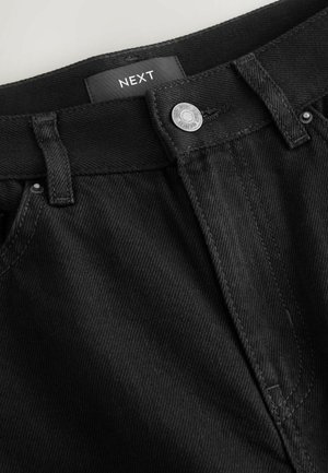 Black denim pants featuring a button closure, belt loops, and tonal stitching. Label "NEXT" visible at the waistband. Texture appears sturdy.
