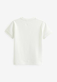 Tricou cu mânecă scurtă, de culoare crem deschis, cu un model texturat în formă de vafe, având un guler rotund și o margine dreaptă. Vedere din spate.
