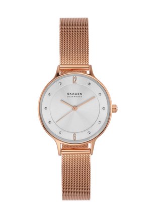 Reloj de pulsera Skagen en oro rosa con correa de malla, esfera blanca, marcadores mínimos y agujas finas que muestran las 1:43:38.