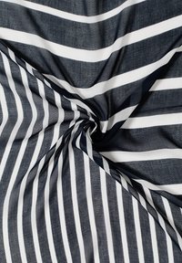 Tissu rayé bleu marine et blanc, présentant des rayures larges et étroites alternées avec une surface légèrement texturée. Drape fluide et finition douce.