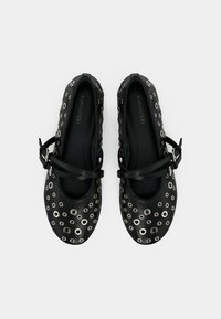 Μαύρα μπαλαρίνα με διακοσμητικές ασημένιες τρύπες, υφή στην επιφάνεια και λουράκι πάνω από την περιοχή του κουντεπιέ. Λεπτότατη εσωτερική επένδυση, στρογγυλερό σχέδιο στα δάχτυλα.