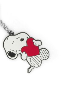 Portachiavi con un personaggio Snoopy sorridente che tiene un cuore rosso, contornato in nero, con un attacco a catena argentata e piedi a strisce.