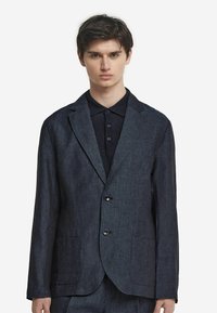 Mörkblå linneblazer med två framfickor och en knappstängning, med slagkrage och strukturerad tyg.