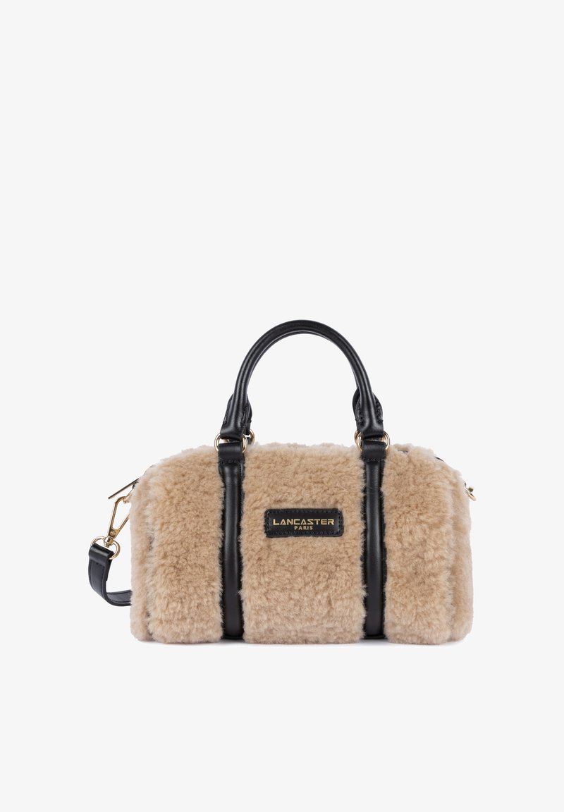 Borsa a mano in pelliccia sintetica color tan con dettagli in pelle nera, doppi manici superiori e tracolla regolabile. Presenta una placca con logo dorato.