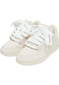 Lys beige sneakers med semsket og mesh-paneler, tykke hvite lisser og en teksturert gummisåle. Rund tå og sydde detaljer til stede.