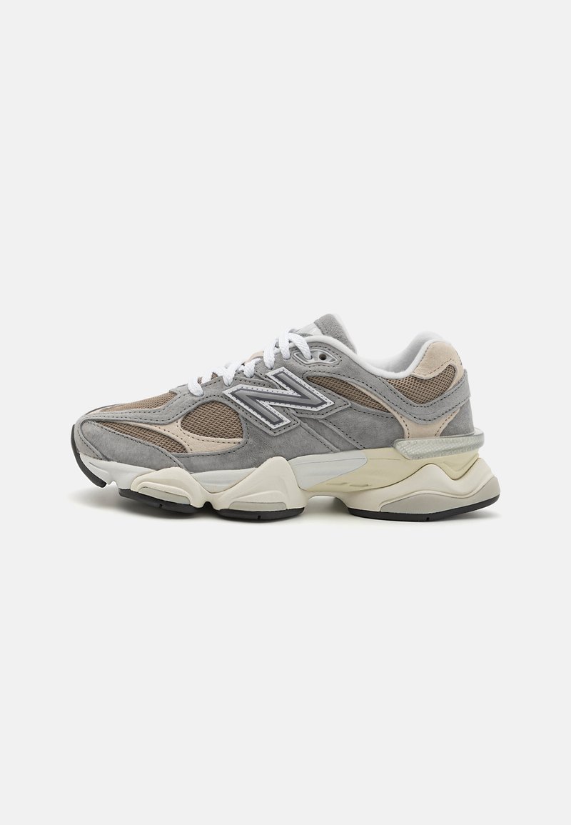 Gray suede and mesh sneaker with a thick white and black sole, featuring a prominent side logo and subtle beige accents.