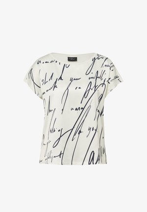 Weiße Kurzarmbluse mit schwarzem abstraktem Schriftmuster und rundem Ausschnitt, Markenlabel am Kragen vor einfarbigem Hintergrund.