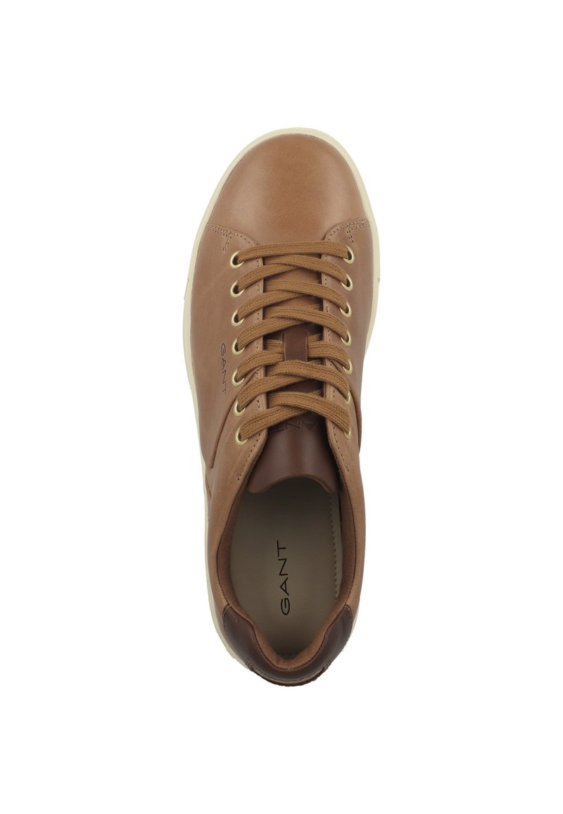 Zapatilla de cuero marrón con puntera redonda, ojales dorados, cordones marrones y suela blanca. Presenta una impresión del logo en el lateral y una textura suave.